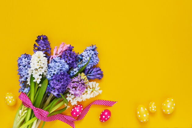 束黄色复活节背景黄色背景上有春天的花朵和装饰性的复活节彩蛋复制空间油漆问候语风信子