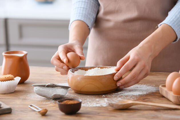 测量在厨房桌子上做面团的女人烹饪不同的面团