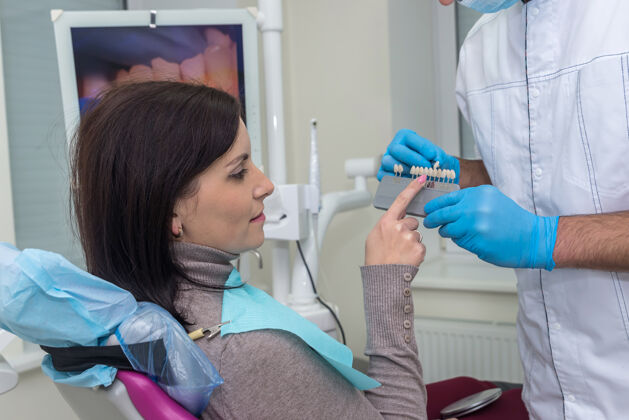 精细牙科的女人指着牙齿采样器专业正畸健康