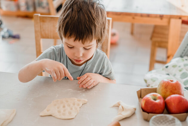 准备可爱的小男孩在厨房准备面团做糕点面包小厨房