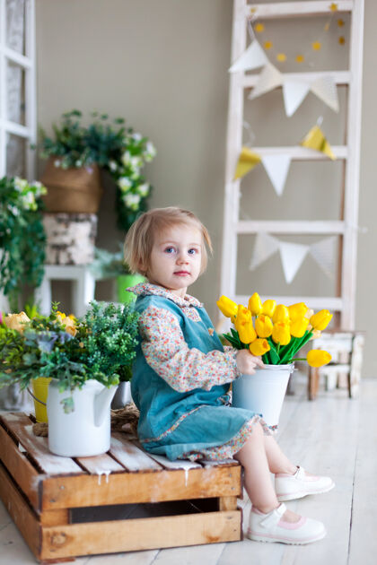 肖像带着一束黄色郁金香的两岁女孩欢呼自然女孩