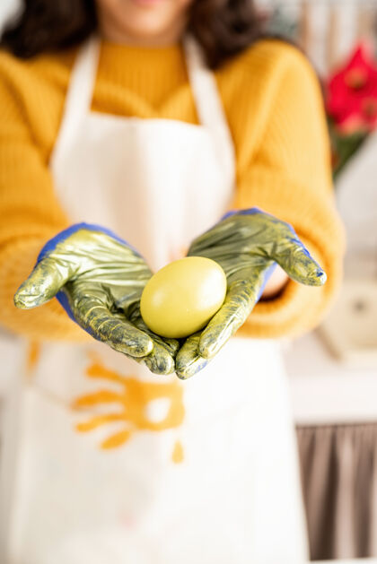 传统手持黄色复活节彩蛋的女人节日鸡蛋工艺