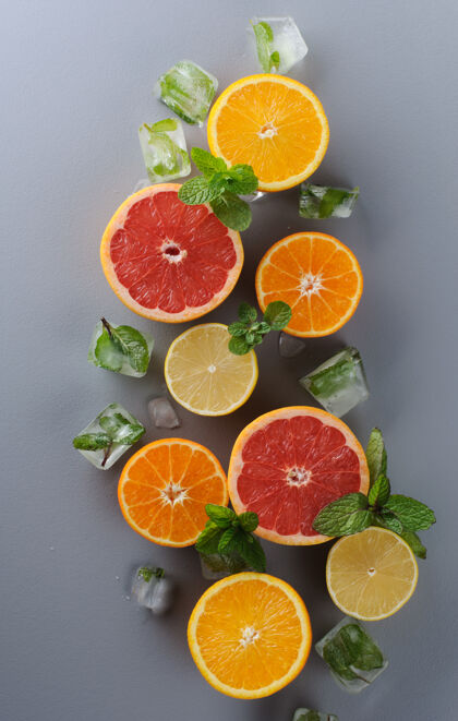 橘子在灰色背景上创造性地布置柑橘类水果多汁多种颜色柑橘类水果