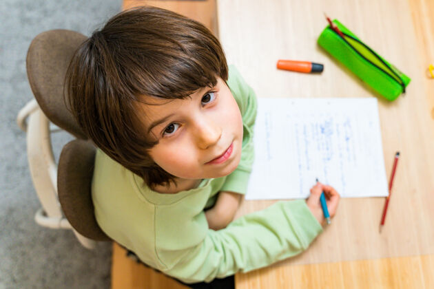 钢笔小男孩坐在家里的桌子旁做作业童年考试锻炼