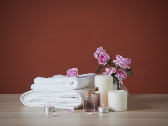 液体美丽的温泉组成与芳香的蜡烛和玫瑰在桌上护肤沙龙洗澡
