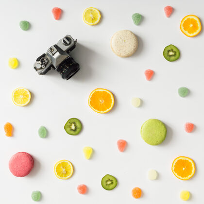 饮食色彩鲜艳的水果图案搭配复古相机和白色糖果墙.平的躺下顶视图食物营养