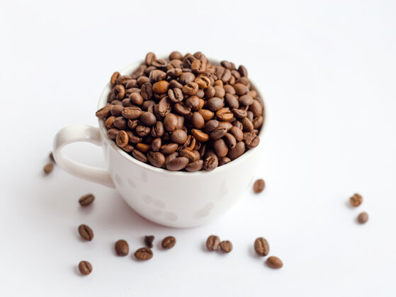 谷物咖啡豆在白色杯中孤立于白色表面 饮品概念酿造火泡沫