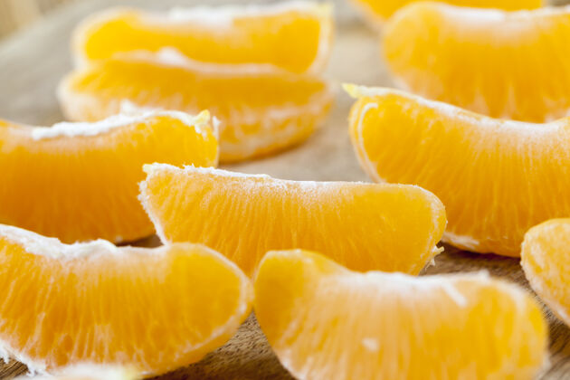 果皮从果皮上剥下多汁的柑桔 在一块旧木板上叠成一排 用照片特写多汁的柑桔果实 分成小片自然克莱门汀柑橘