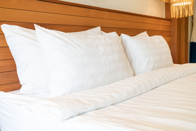 柔软卧室内部床上的白色枕头装饰衣服床单床罩