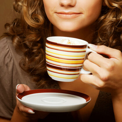 举行年轻漂亮的女人在喝咖啡杯子新鲜巧克力
