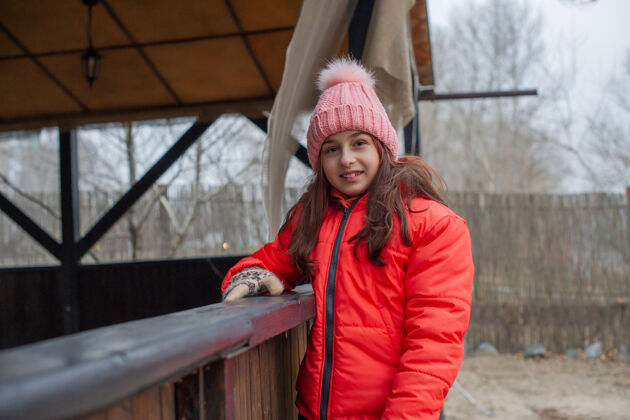 夹克冬天的女孩衣服女孩10年老年人橙色夹克女孩戴着粉色帽子散步湖泊模型女孩