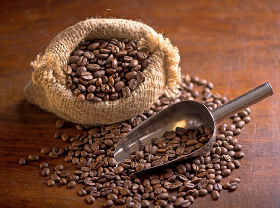 饮料一杯咖啡和咖啡豆放在一个袋子里 背景是深色的 顶视图休息瓷器烤