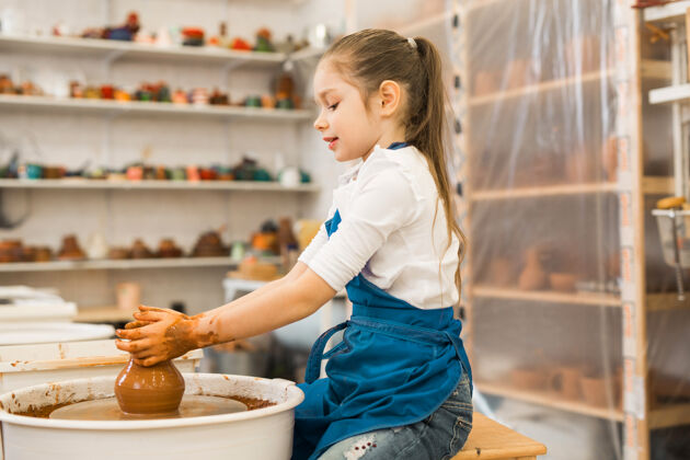 花瓶漂亮的小女孩在陶艺作坊里做陶罐陶器女孩陶瓷