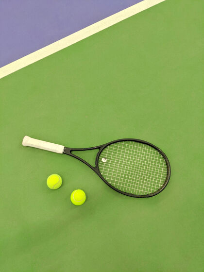 网球网球拍和两个球在绿泥网球场上的俯视图运动球拍活跃