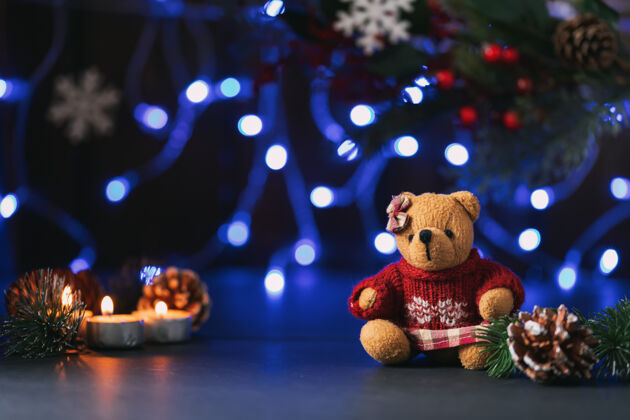 花环气氛圣诞节或新年组成与泰迪熊 锥 蜡烛 冷杉枝和花环树枝照明蜡烛