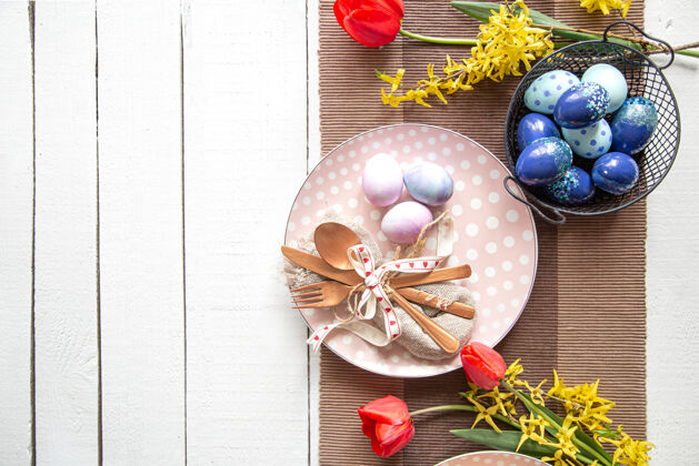 装饰盘子里有复活节蛋糕 鲜花和复活节蛋糕鸡蛋桌子复活节假期复印空间的设置组成花卉顶视图