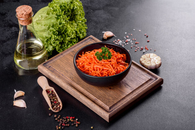 开胃菜美味 辛辣 多汁 明亮的韩国胡萝卜 放在深色水泥上的陶瓷盘子里背景.亚洲人美食辛辣木头蔬菜