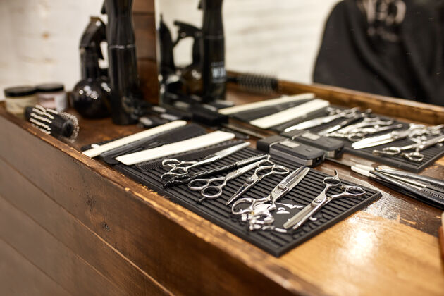 镜子理发店的木架和镜子上的理发工具剪刀商店剃须刀