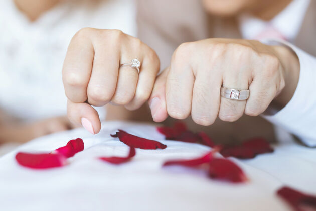 两个人结婚的男人和女人戒指年轻的新婚夫妇牵手 举行婚礼新的一天用结婚戒指把这对新人的手娶了男性夫妻退休