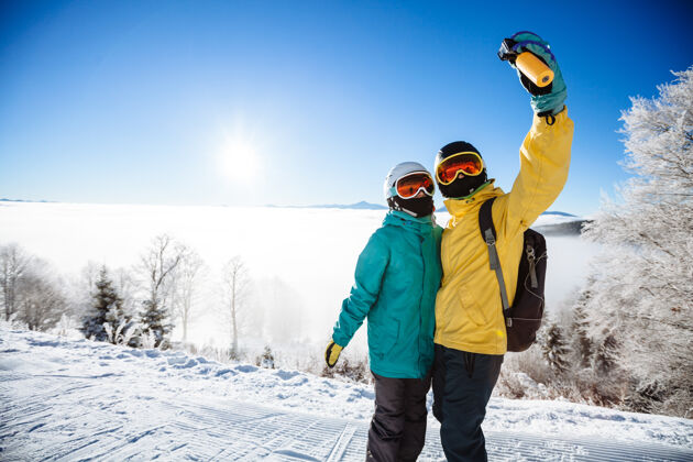 娱乐滑雪者在山上用智能手机拍照冬天女朋友图片