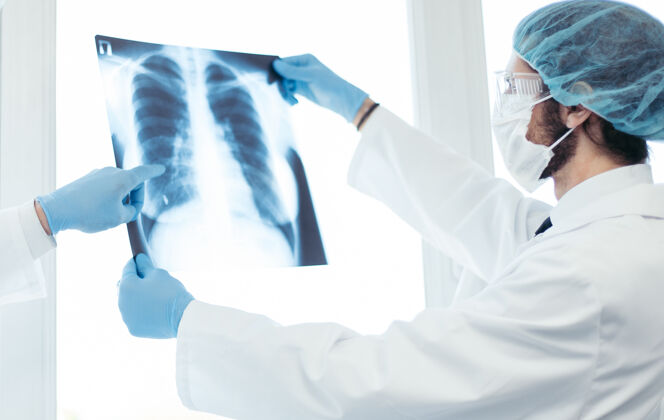 疾病关闭起来医生戴着防护面罩讨论肺部x光检查健康护理的概念肺炎测试放射照相