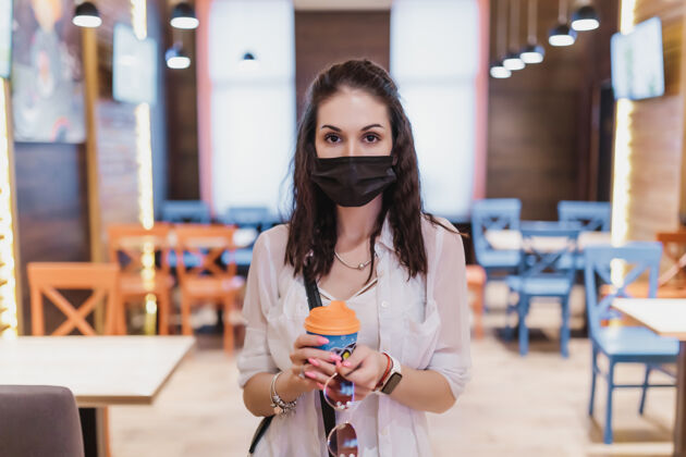女性一个戴着病毒面具的年轻女子咖啡城市在隔离高质量服务员冠状病毒防护