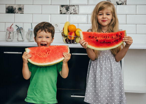 水果三个快乐微笑的孩子在厨房里吃西瓜快乐食物健康