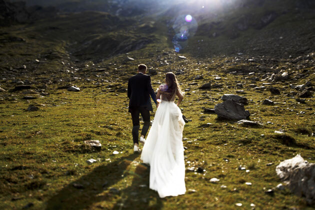 男性后景：一对面目全非的新娘和新郎手牵着手在山上迎着日出奔跑套装妻子成人