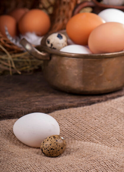棕色木制褐蛋篮子坏了背景是蛋黄的鸡蛋春天稻草复活节