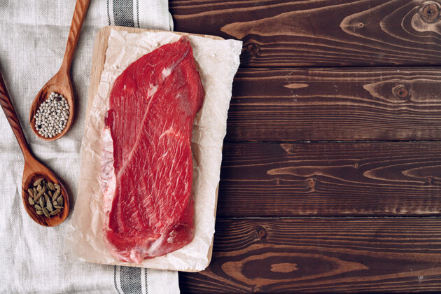 新鲜生肉牛肉片放在棕色木板上特写牛肉食物木材
