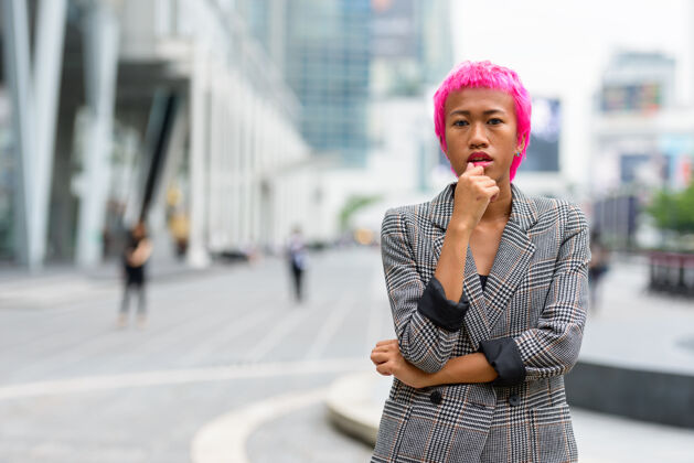 古怪年轻叛逆的亚洲女商人的画像 粉红色的头发 在城市街道户外城市景观街道现代