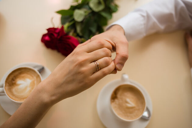 情人节把一个手里拿着结婚戒指的女人交给桌上的一个男人情感婚礼手