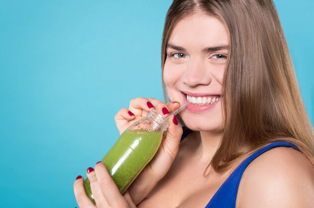加上大小健康的消耗关闭美丽的年轻快乐的女人拿着一瓶绿色的饮料过剩美丽果汁