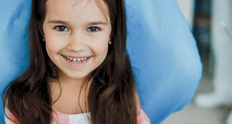 年轻漂亮的小女孩在做完牙齿检查后坐在口腔科的座位上牙科黑发检查
