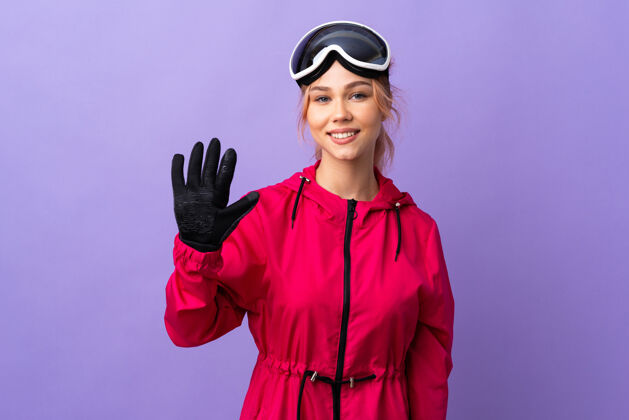 计数滑雪女孩戴着滑雪板上的眼镜 用手指数着五个手指青年数字