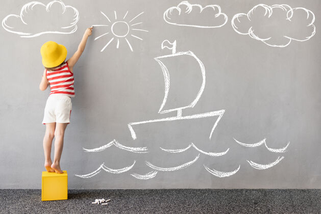 海梦想大快乐的孩子在墙上画一个粉笔船冒险幼儿混凝土