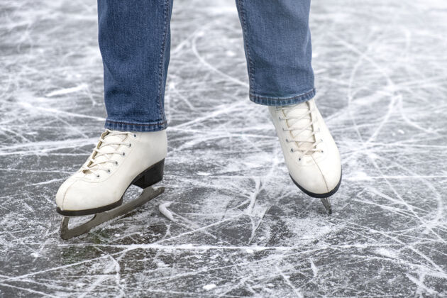 溜冰穿着冰鞋和牛仔裤在冰上休闲的女人休闲休闲活动溜冰场