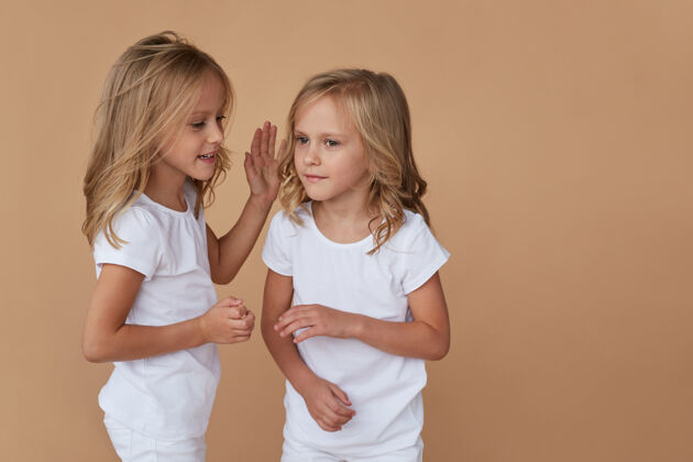 妹妹正面特写可爱的金发小双胞胎姐妹的肖像 互相交谈女孩金发家庭