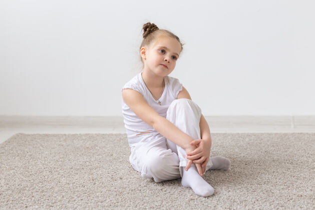 小穿白衬衫的孩子坐在地板上年轻沉思小