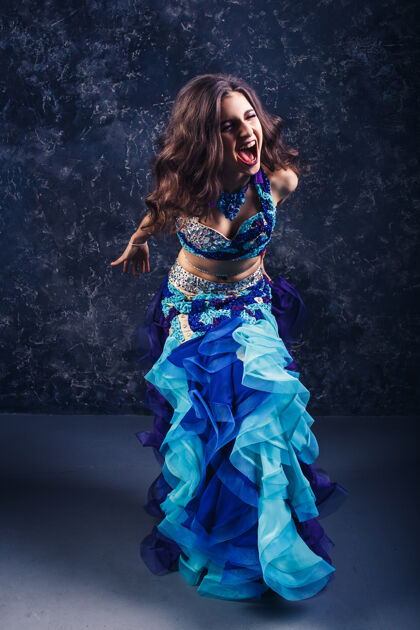 头饰年轻漂亮的女孩穿着蓝色西装跳肚皮舞部落亚洲人传统