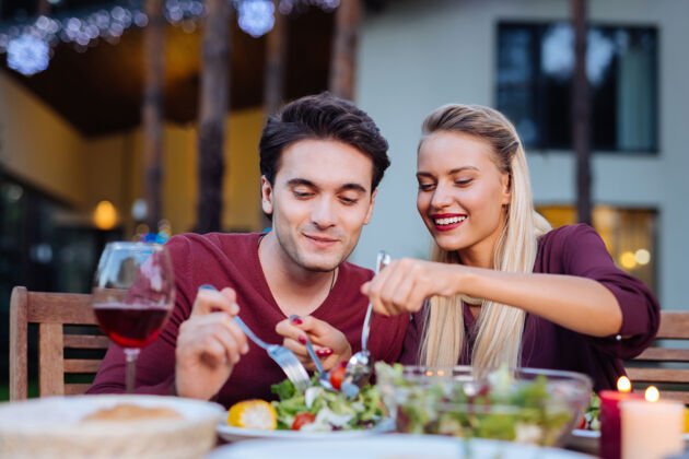 餐厅美食佳肴一对幸福的夫妇一边在餐厅享受美食 一边品尝蔬菜沙拉感觉关系愉悦