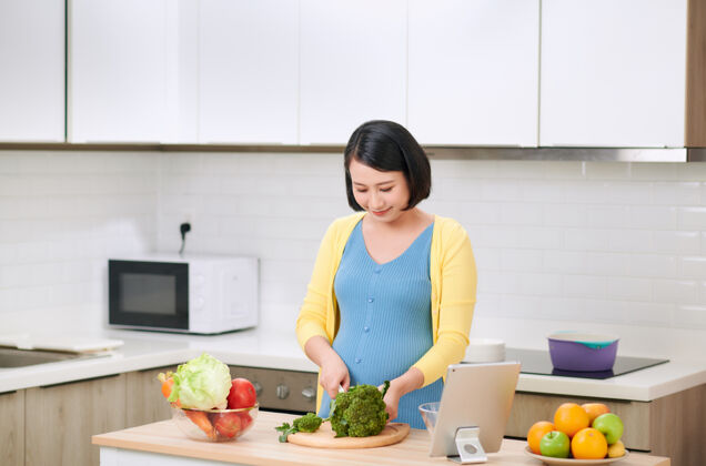 中国菜孕妇切西兰花做新鲜蔬菜沙拉 女性在家准备美味的有机晚餐营养厨房切