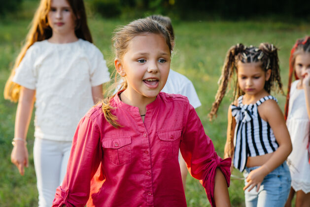 玩日落时分 一群快乐的孩子在公园里奔跑玩耍夏令营小学生活跃游戏