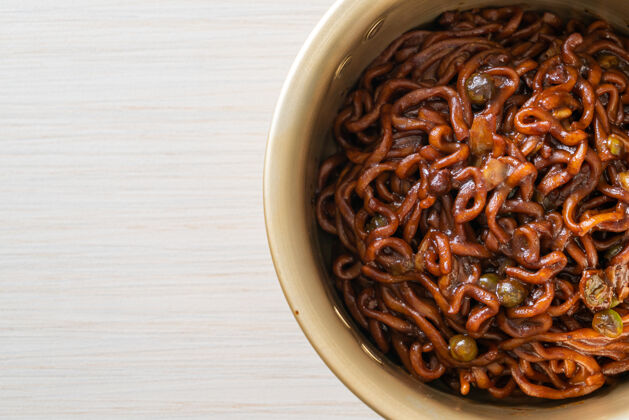 烹饪韩国黑意大利面或方便面配烤茶蓉酱油（chapagetti）-韩国风味亚洲筷子特写