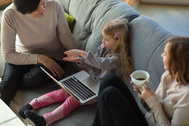美麗相聚家庭幸福祖母 母親和女兒一起度過時光看電影 使用筆記本電腦 歡笑母親節 慶祝 周末 假日和童年的概念關懷擁抱父母