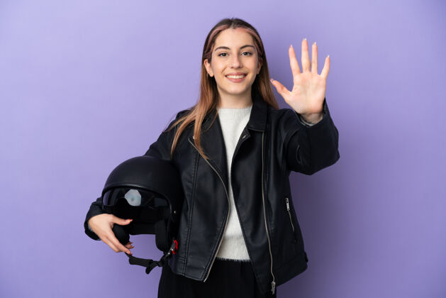 女年轻的摩托车手拿着摩托车头盔成人司机自行车