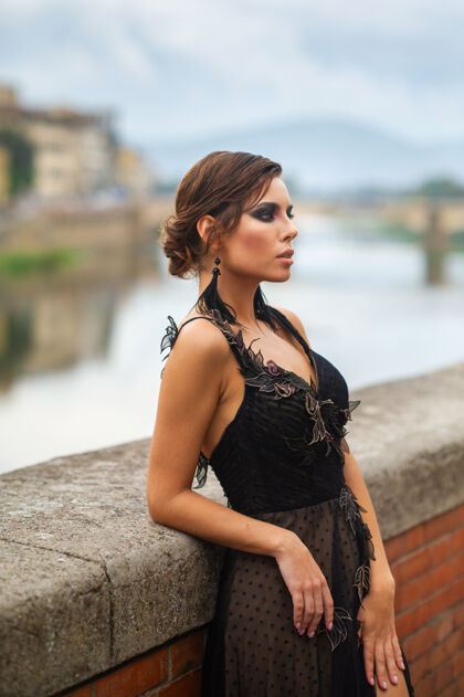 佛罗伦萨在意大利佛罗伦萨 身着黑色礼服的美丽时尚新娘站在堤岸上新娘古城女人