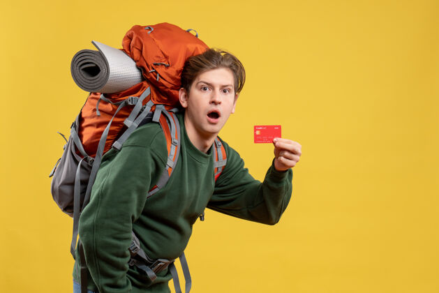 年轻男性正面图年轻男子手持红色银行卡准备远足准备旅游成人