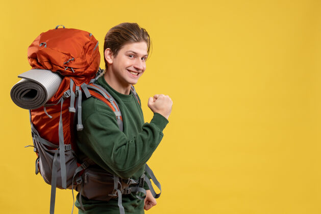 黄色正面图年轻男子背着背包准备远足徒步旅行背包人