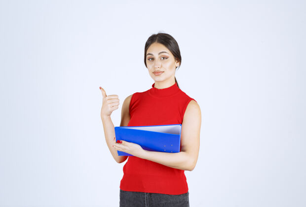 模特穿着红衬衫的女孩手里拿着一个蓝色的商业文件夹年轻人助理职员